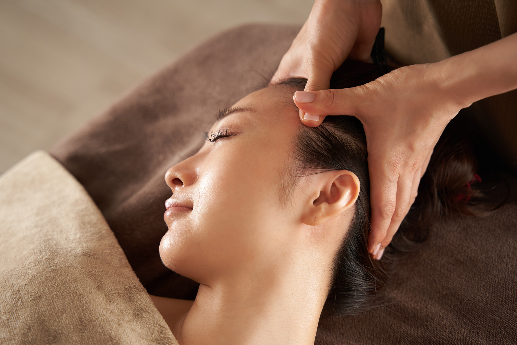 Japanese woman receiving a facial massage at an aesthetic salon